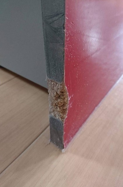 ペットにかじられた傷、キッチン下台側板の赤色の鏡面パネルです。鏡面塗装の赤、木口は艶消しの黒で仕上げます。